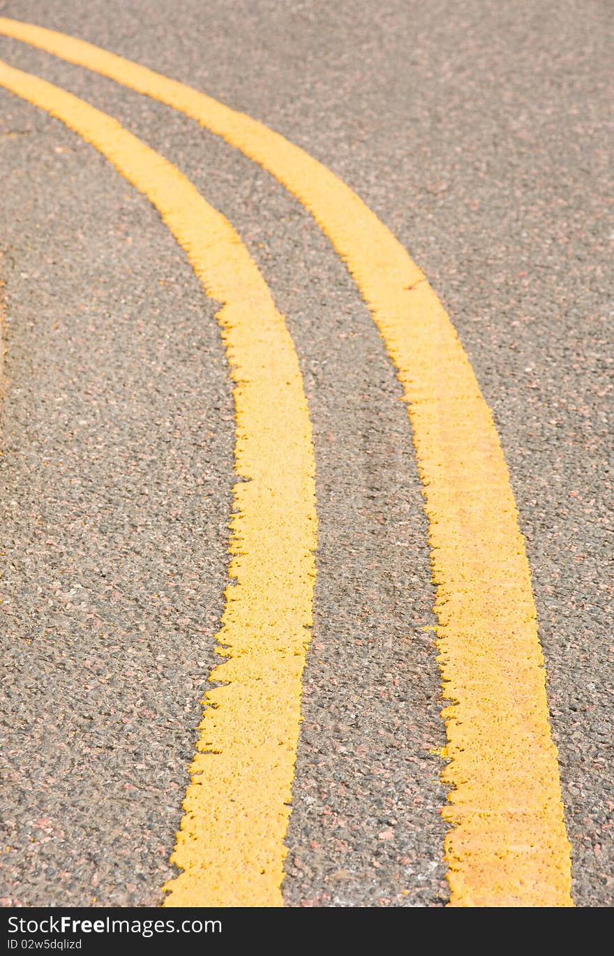 An image of a road on a curve with double yellow lines indicating that parking is not allowed at any time. An image of a road on a curve with double yellow lines indicating that parking is not allowed at any time.