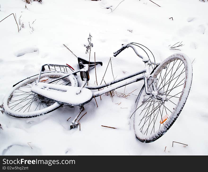 Bicycles covered with snow lay on the ground. Bicycles covered with snow lay on the ground