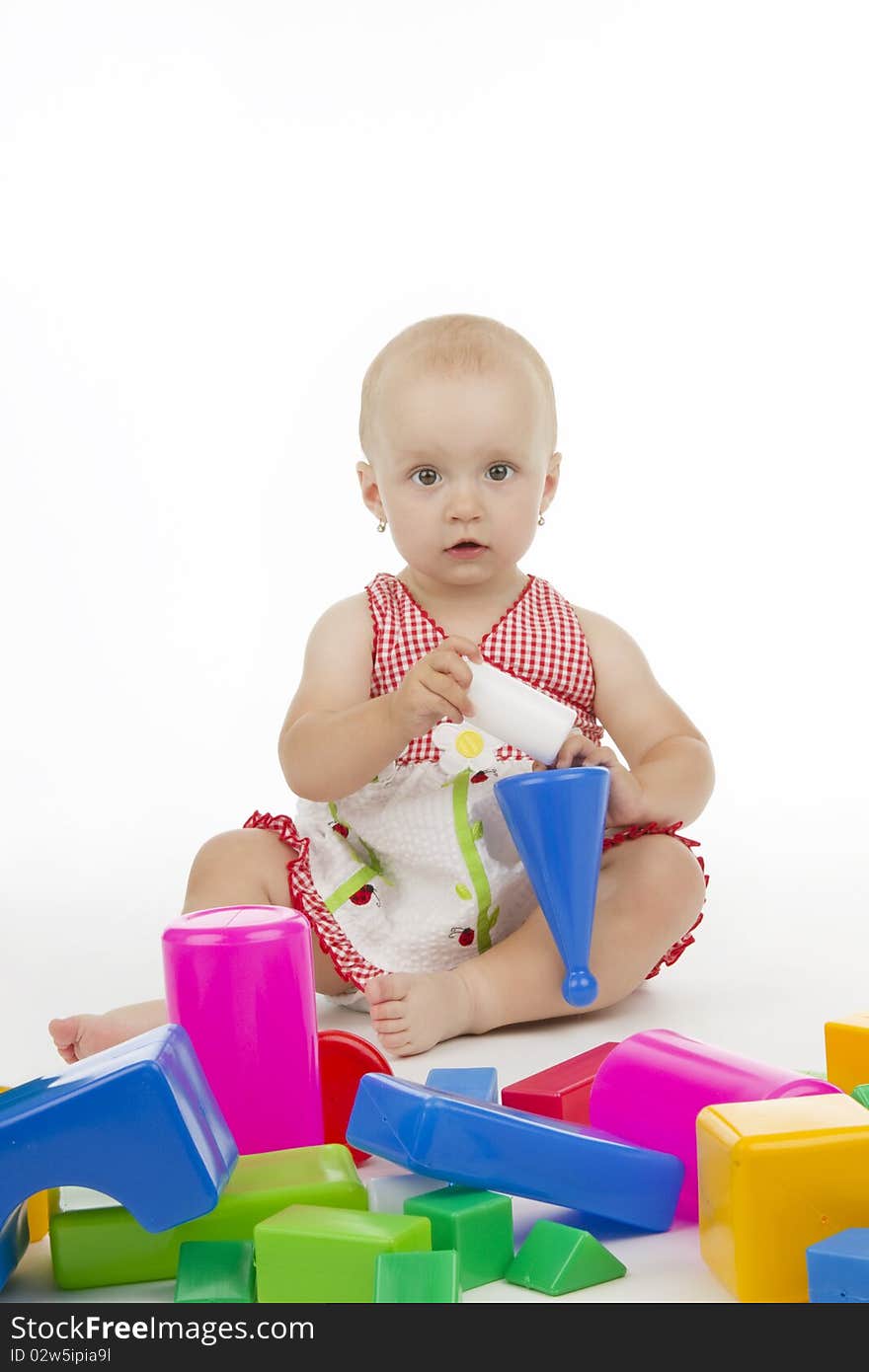 Dinky little girl plaies with plastic cubes, on white background. Dinky little girl plaies with plastic cubes, on white background.