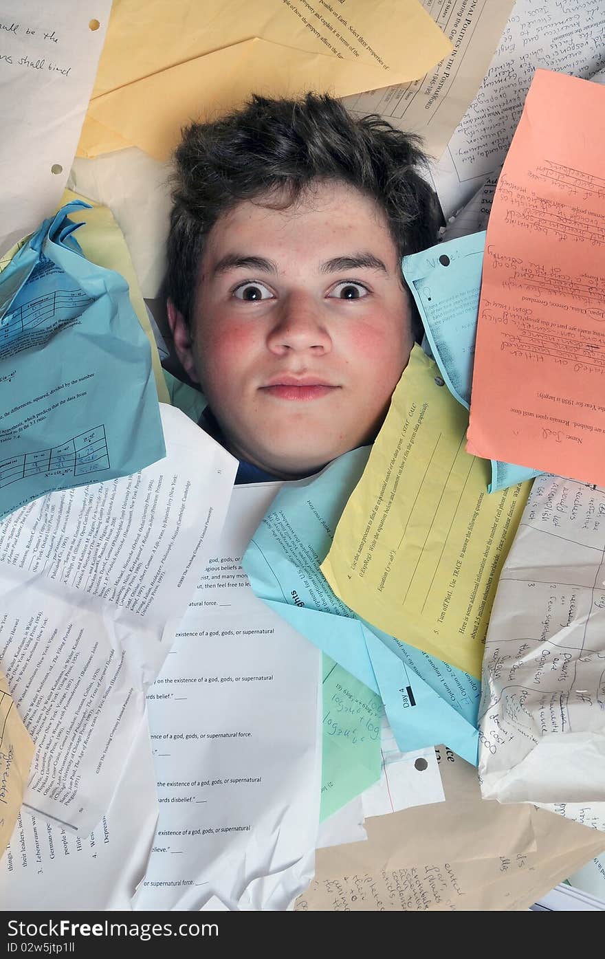 Young male student is overwhelmed by way too many homework assignments. Young male student is overwhelmed by way too many homework assignments.