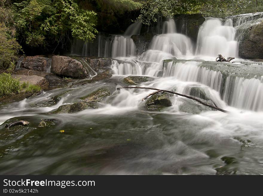 Long exposure of a waterfall with a wooden stick from a branch. Long exposure of a waterfall with a wooden stick from a branch.