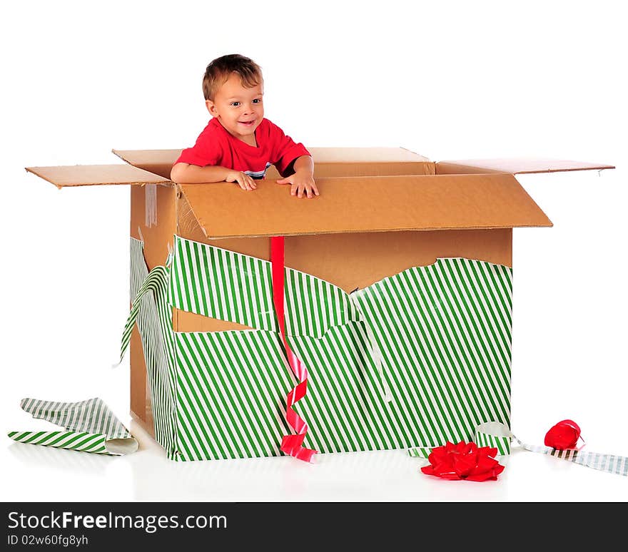 A happy preschooler playing in a giant-sized boy with the left-over wrappings from Chistmas. Isolated on white. A happy preschooler playing in a giant-sized boy with the left-over wrappings from Chistmas. Isolated on white.