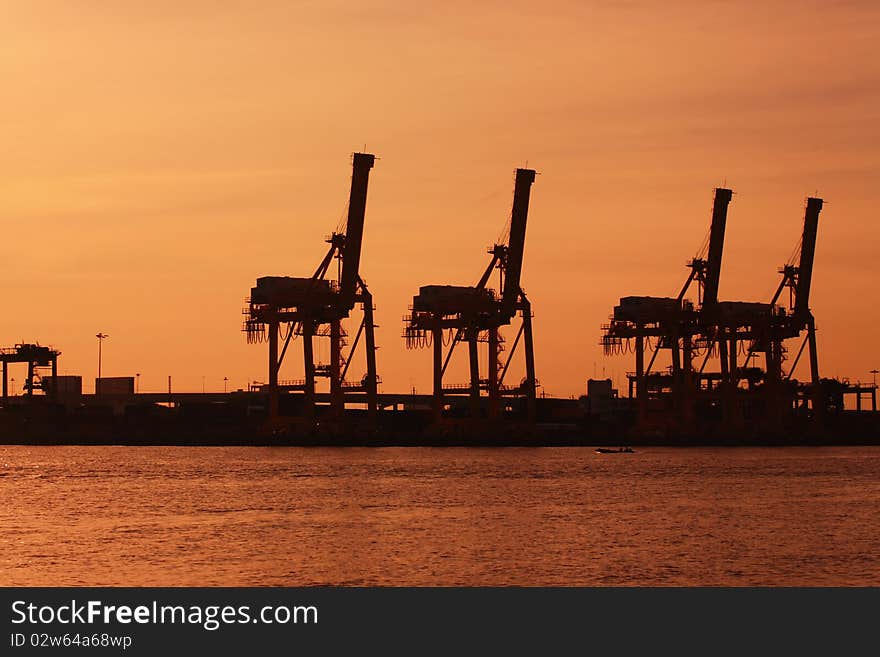 Port warehouse with cargoes and containers at sunrise