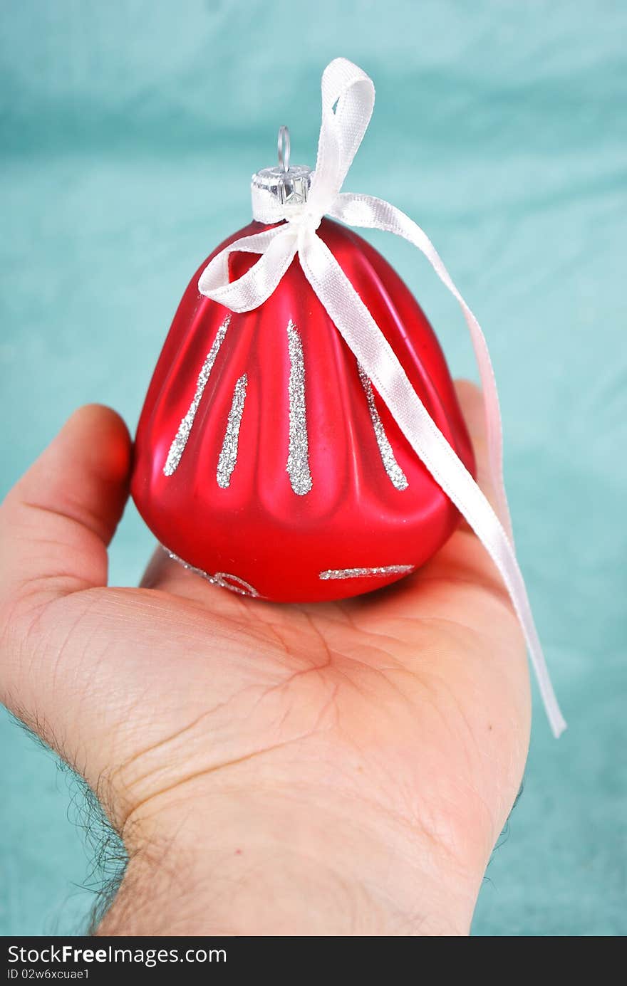 Hand holding red Christmas ball