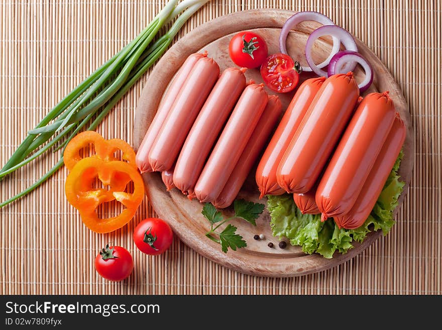 Boiled sausage, on a wooden cutting board.