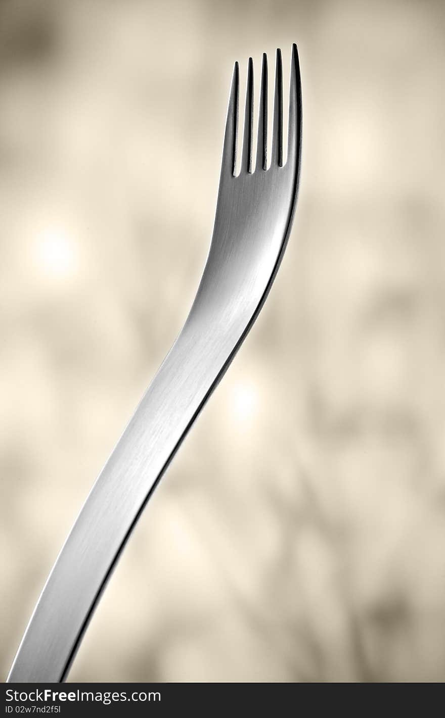 Designer fork in front of light background.