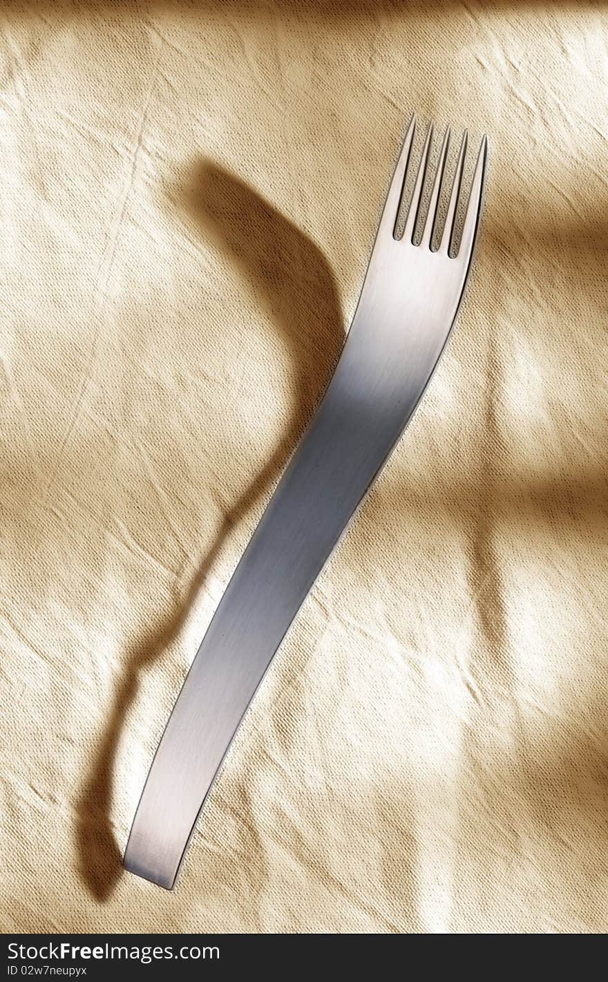 Designer fork in front of light background.