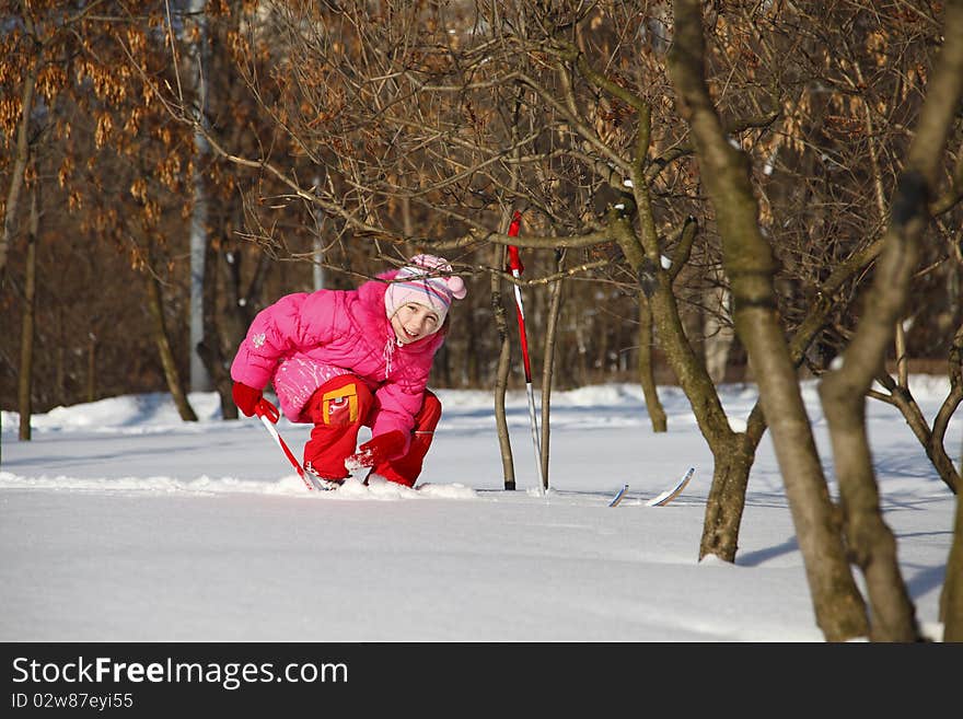 The little girl in a crimson suit on skis. The little girl in a crimson suit on skis