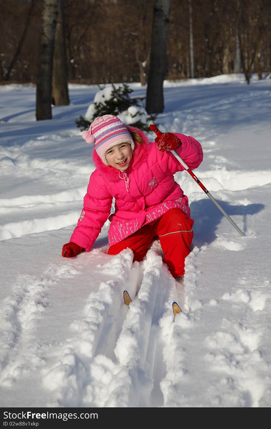 The little girl in a crimson suit on skis. The little girl in a crimson suit on skis