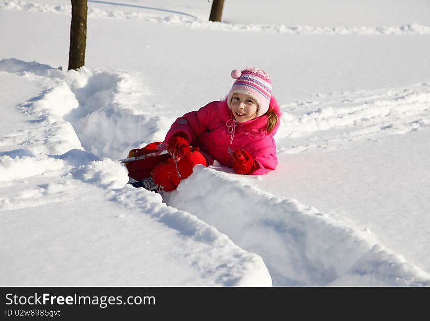 The little girl in a crimson suit on skis. The little girl in a crimson suit on skis