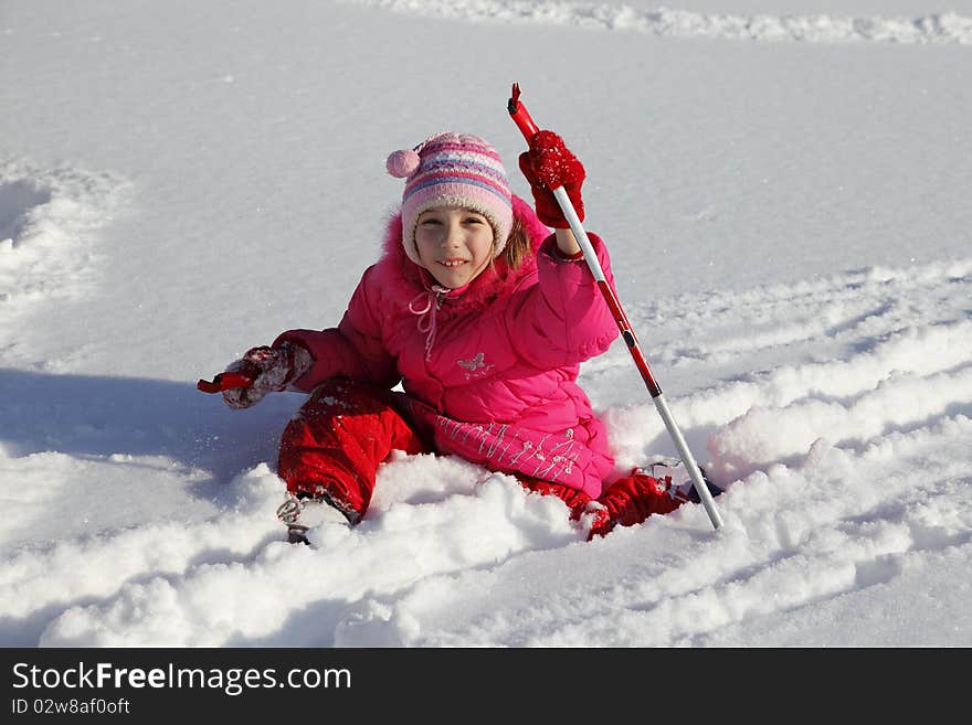 The little girl in a crimson suit on skis. The little girl in a crimson suit on skis