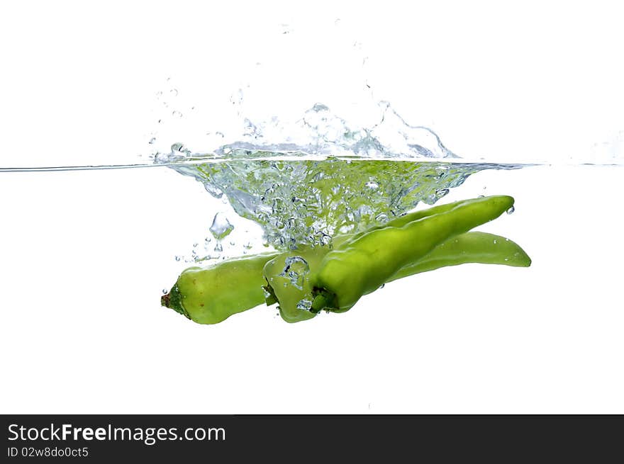 Green chilli thrown in water with white background. Green chilli thrown in water with white background