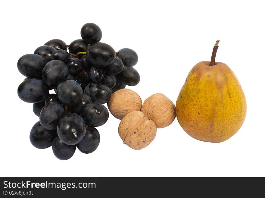 A bunch of grapes, three walnuts and a pear isolated on white background. A bunch of grapes, three walnuts and a pear isolated on white background