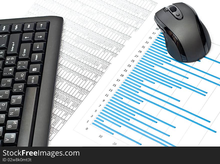 Close-up of keypad, mouse, charts on table. Close-up of keypad, mouse, charts on table