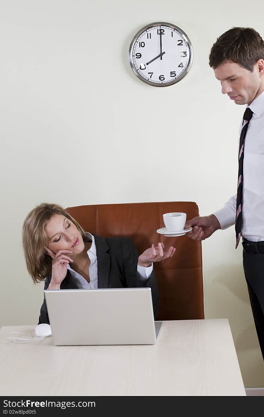 Female manager having coffee served by his male colleague