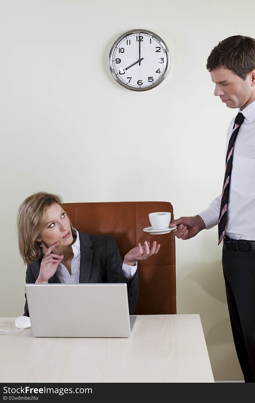 Female manager having coffee served by his male colleague
