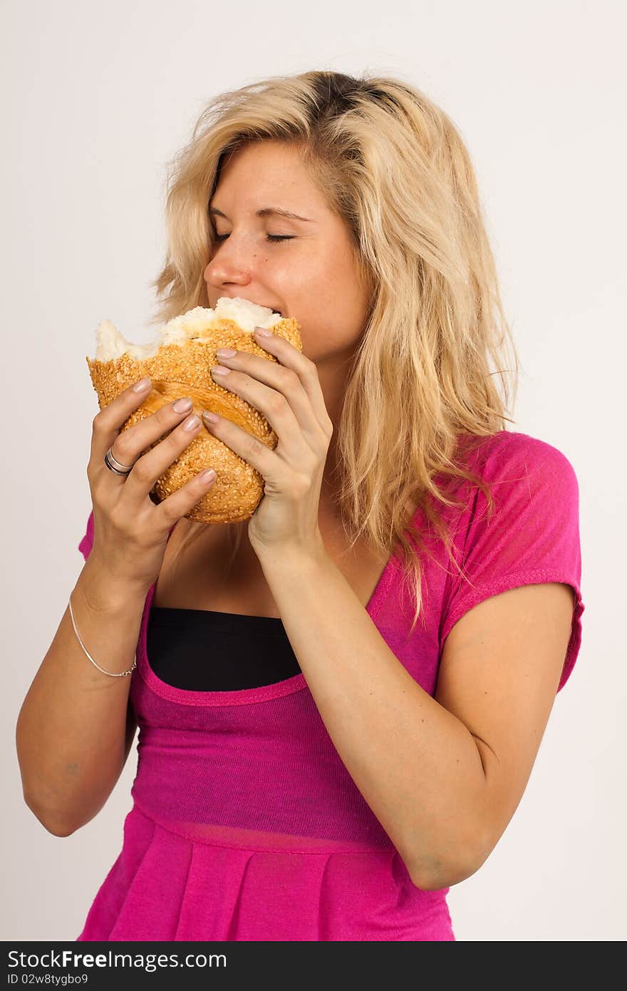 Beautiful brunette girl eating a bread  isolated on the white background. Beautiful brunette girl eating a bread  isolated on the white background