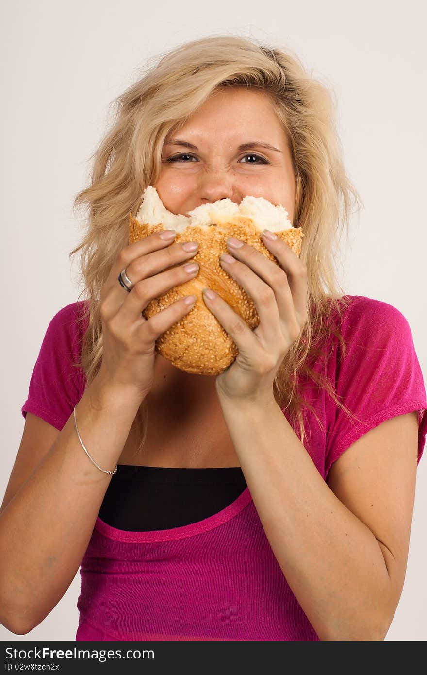 Beautiful brunette girl eating a bread isolated on the white background. Beautiful brunette girl eating a bread isolated on the white background