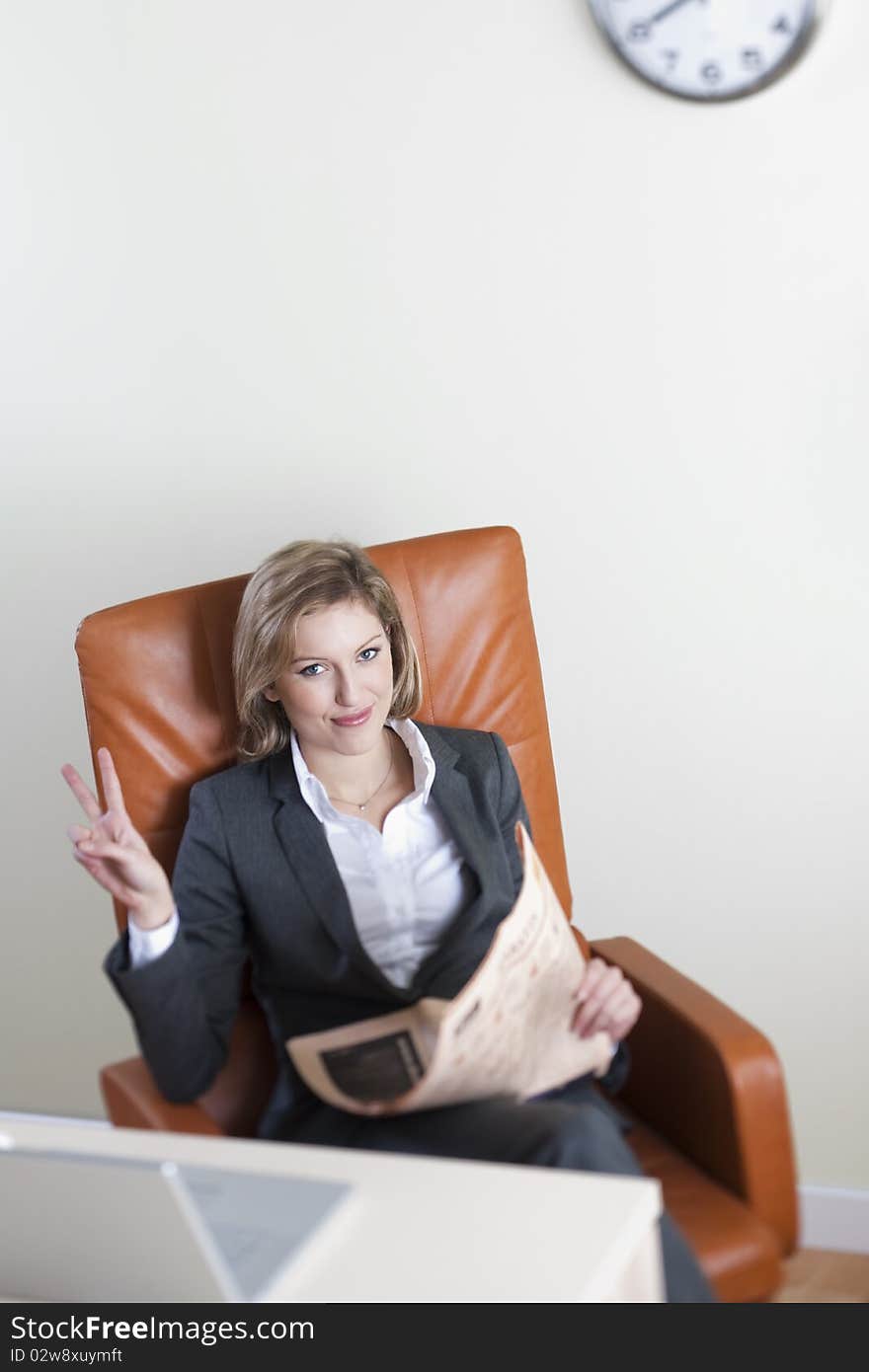 Businesswoman receiving good news while reading newspaper. Businesswoman receiving good news while reading newspaper