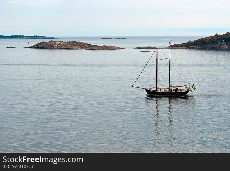 Two-masted ship at sea on the background of the islands