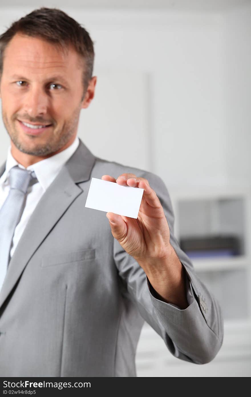 Businessman holding white business card. Businessman holding white business card