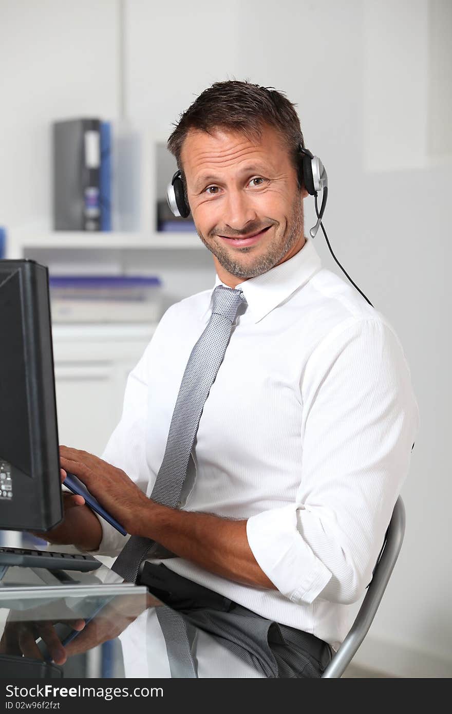 Closeup of businessman in the office with headphones. Closeup of businessman in the office with headphones