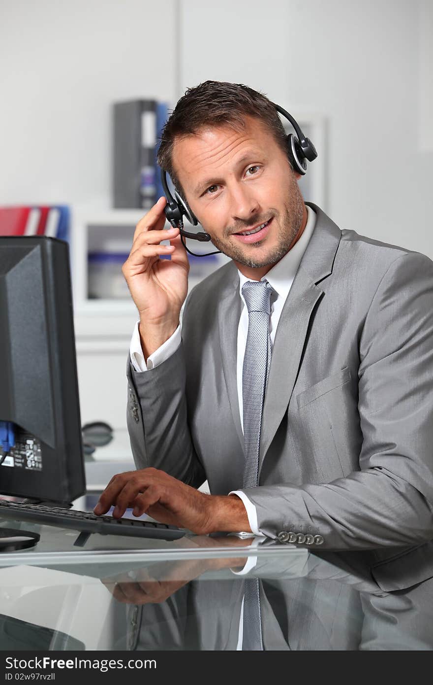 Closeup of businessman in the office with headphones. Closeup of businessman in the office with headphones