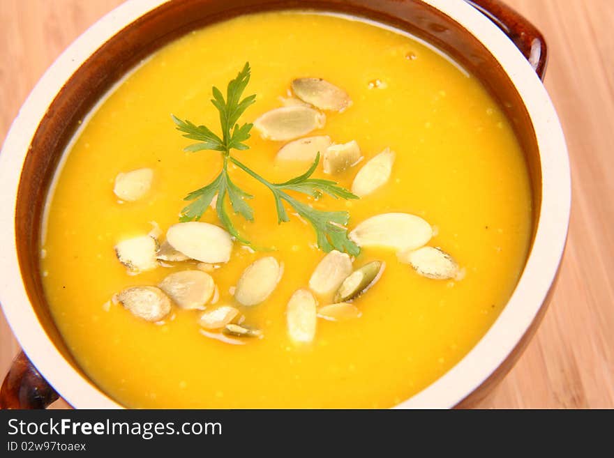 Bowl of pumpkin soup on wooden background