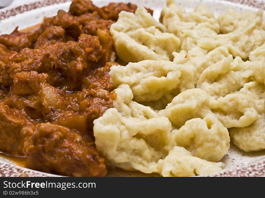 Goulash with gnocchi on a plate. Hungarian food