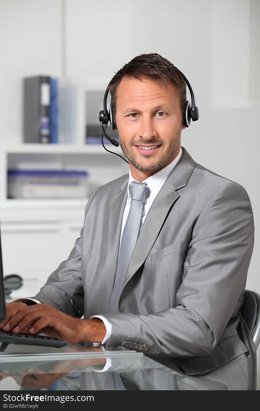 Closeup of businessman in the office with headphones. Closeup of businessman in the office with headphones