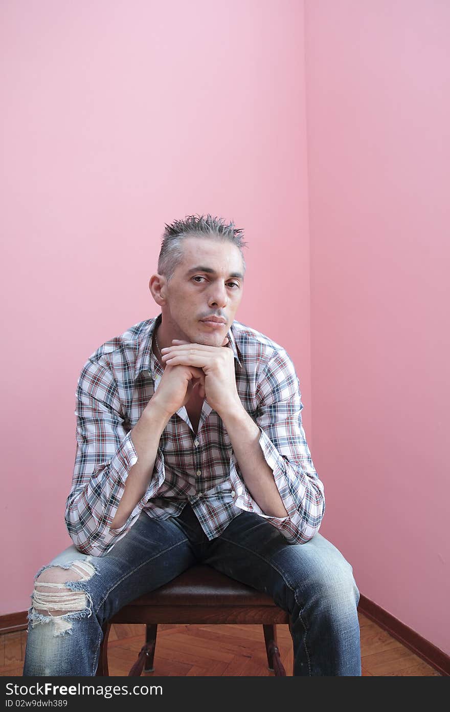 Man in checkered shirt keeps his hands folded