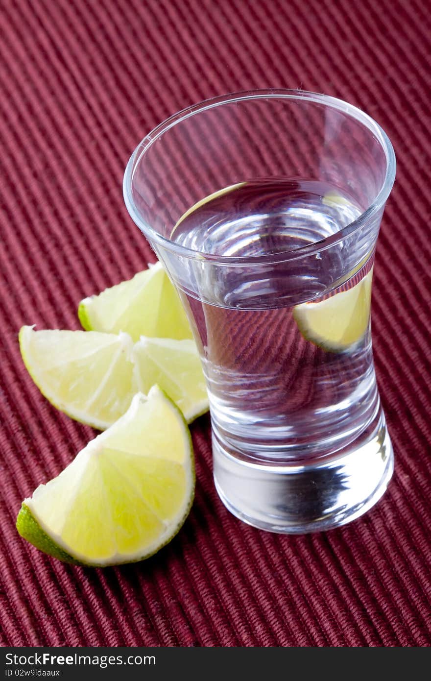 Shot glass filled with clear cold alcohol. Shot glass filled with clear cold alcohol