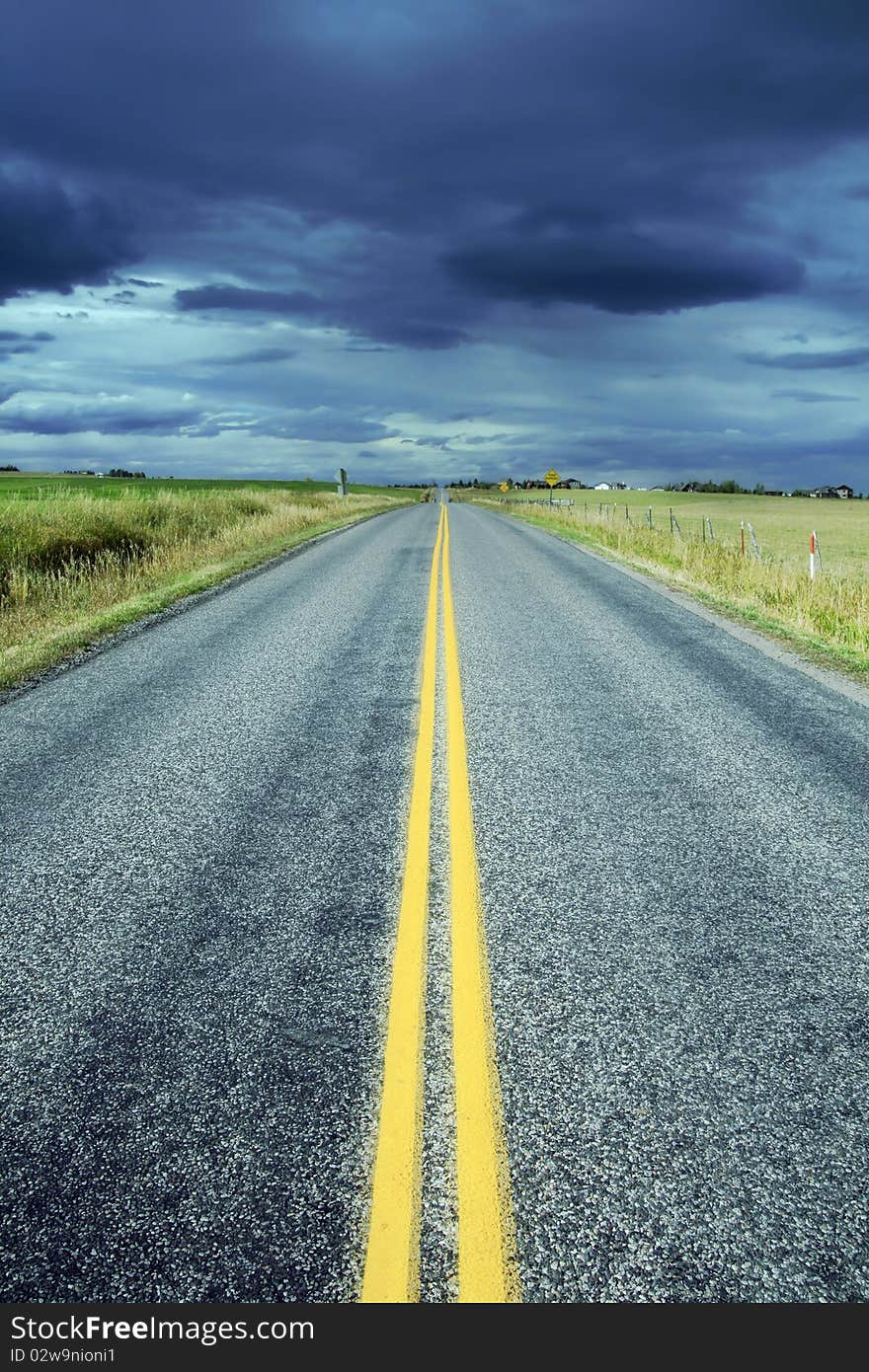 A quiet highway in Montana looking in the direction of a coming storm.