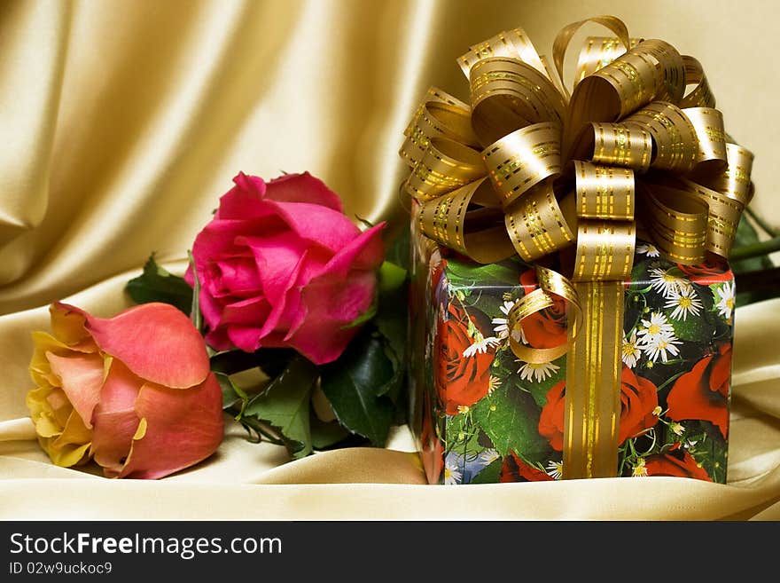 Gift box with flowers on silk background