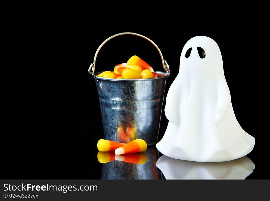 The perfect ghost with a bucket of candy corn and reflection