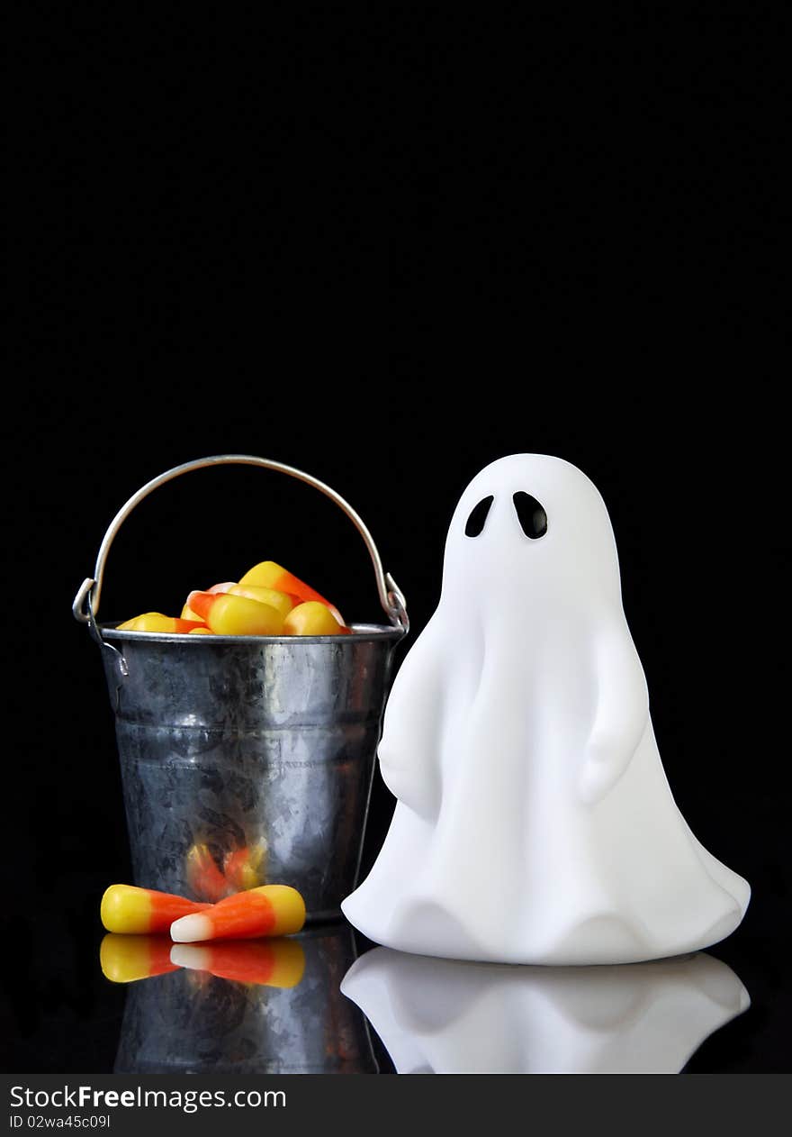 The perfect ghost with a bucket of candy corn and reflection