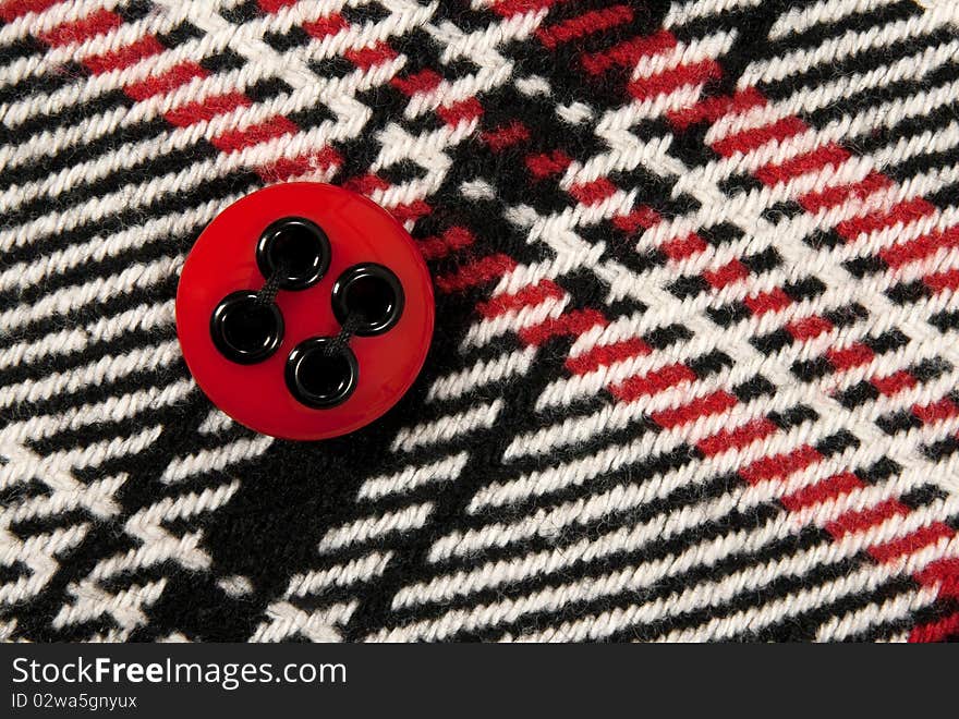 Plastic red button on a stylish checked fabric. Plastic red button on a stylish checked fabric.