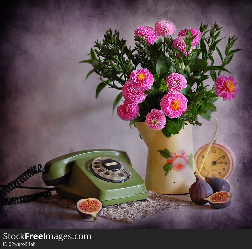 Still life with a green telephone, pink flowers, clock and fig. Still life with a green telephone, pink flowers, clock and fig