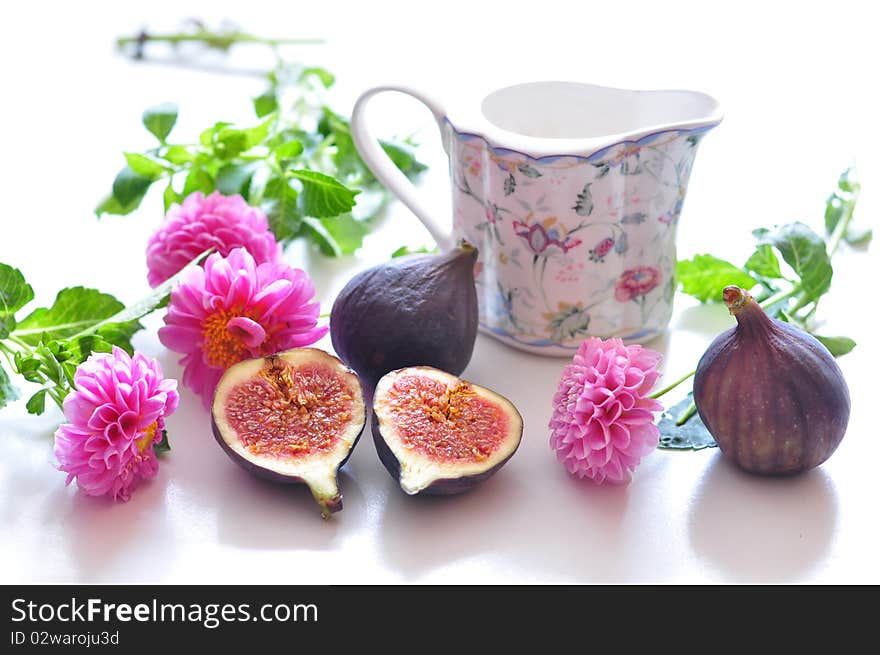 Still life consists of pink flowers and fig