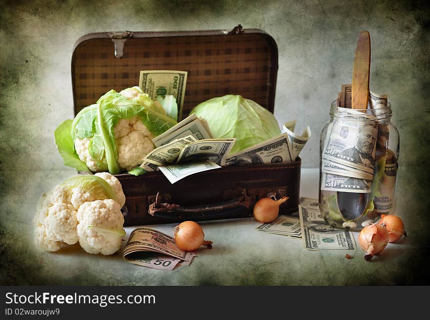 A cabbage and dollars are in a suitcase