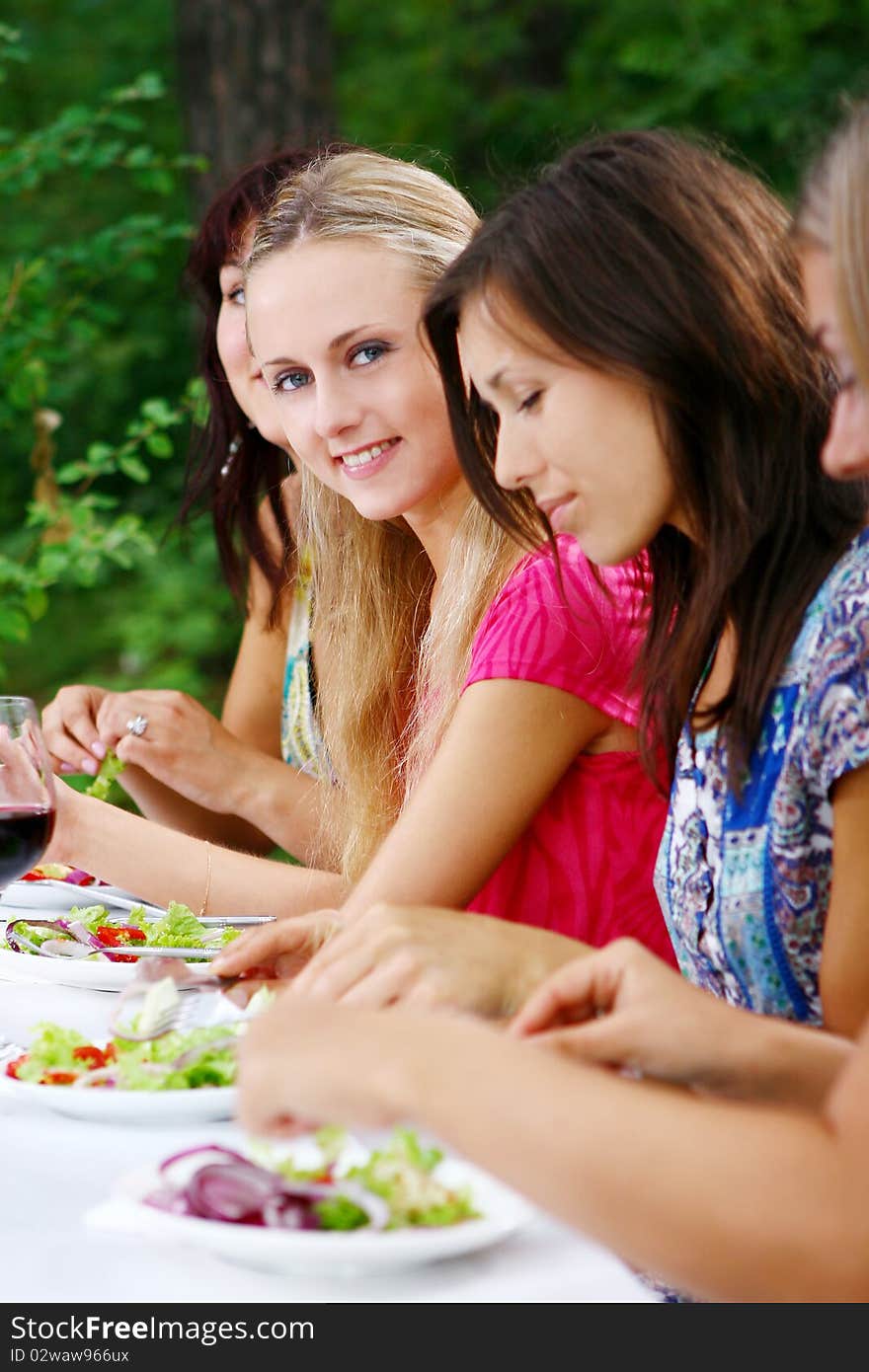 Group of beautiful girls drinking wine in the park