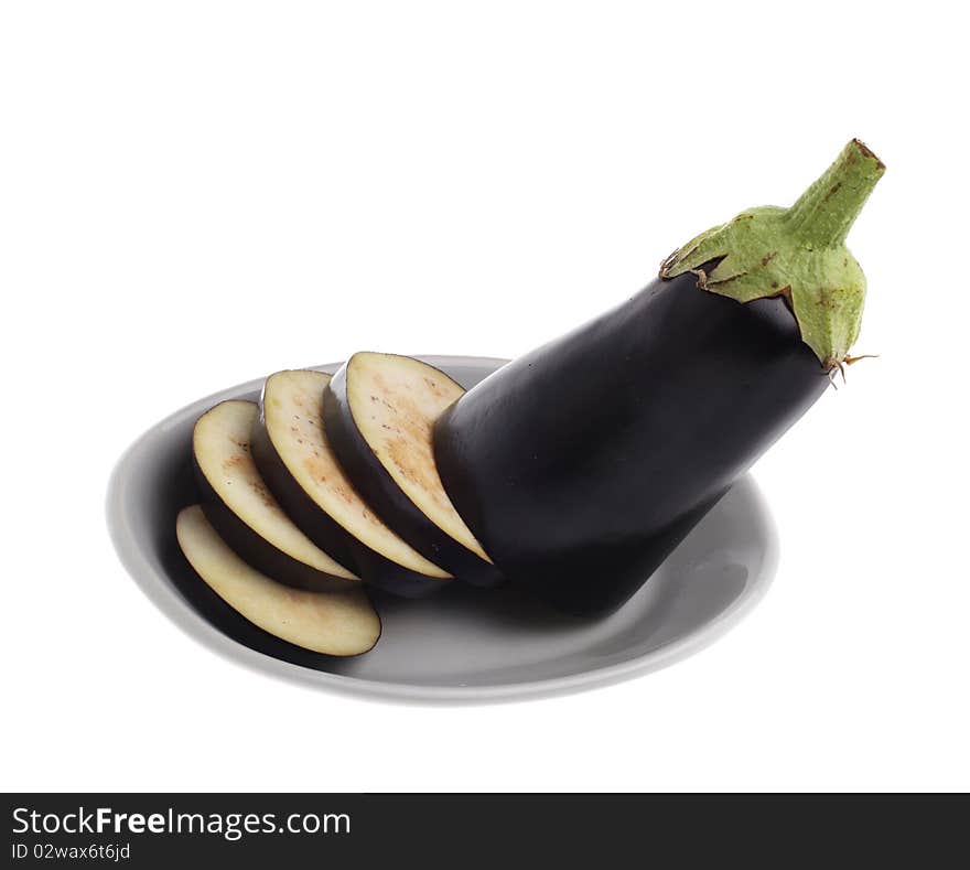 Sliced egg-plant on plate isolated over white background