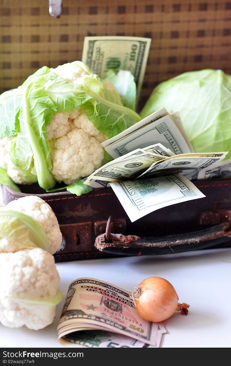 A cabbage and dollars are in a suitcase