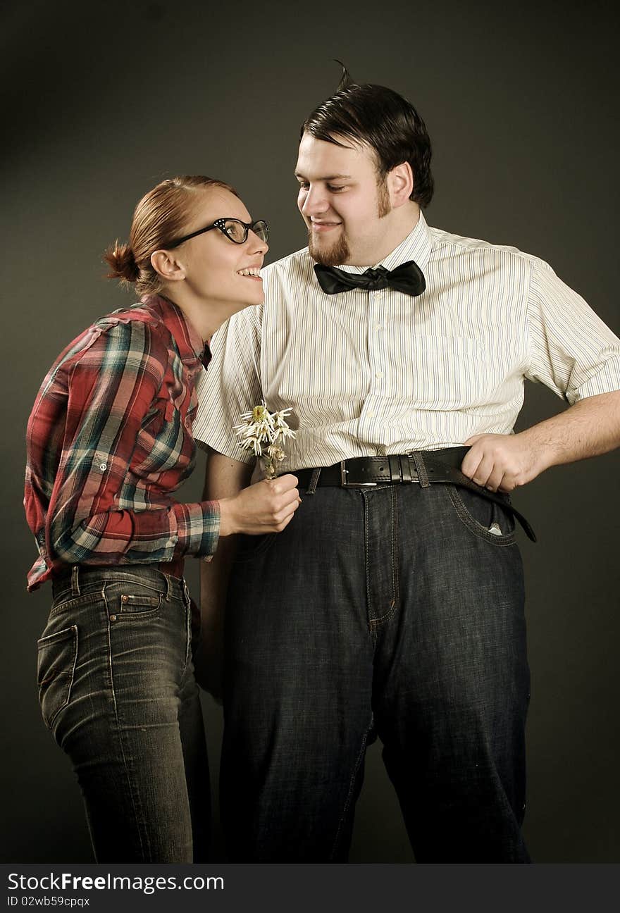 Eccentric young couple on dark background