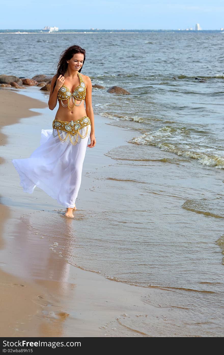 Beautiful young girl walking on beach