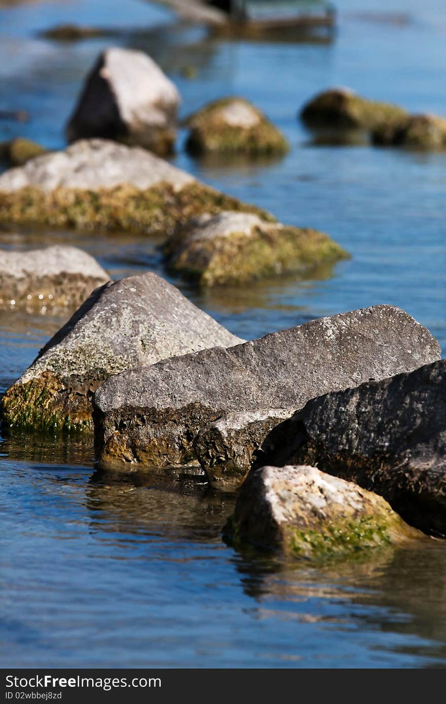 Beautiful waterfront mossy rocks in sunshine