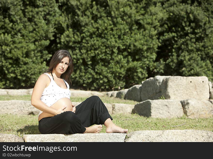 Beautiful pregnant woman relaxing in the park