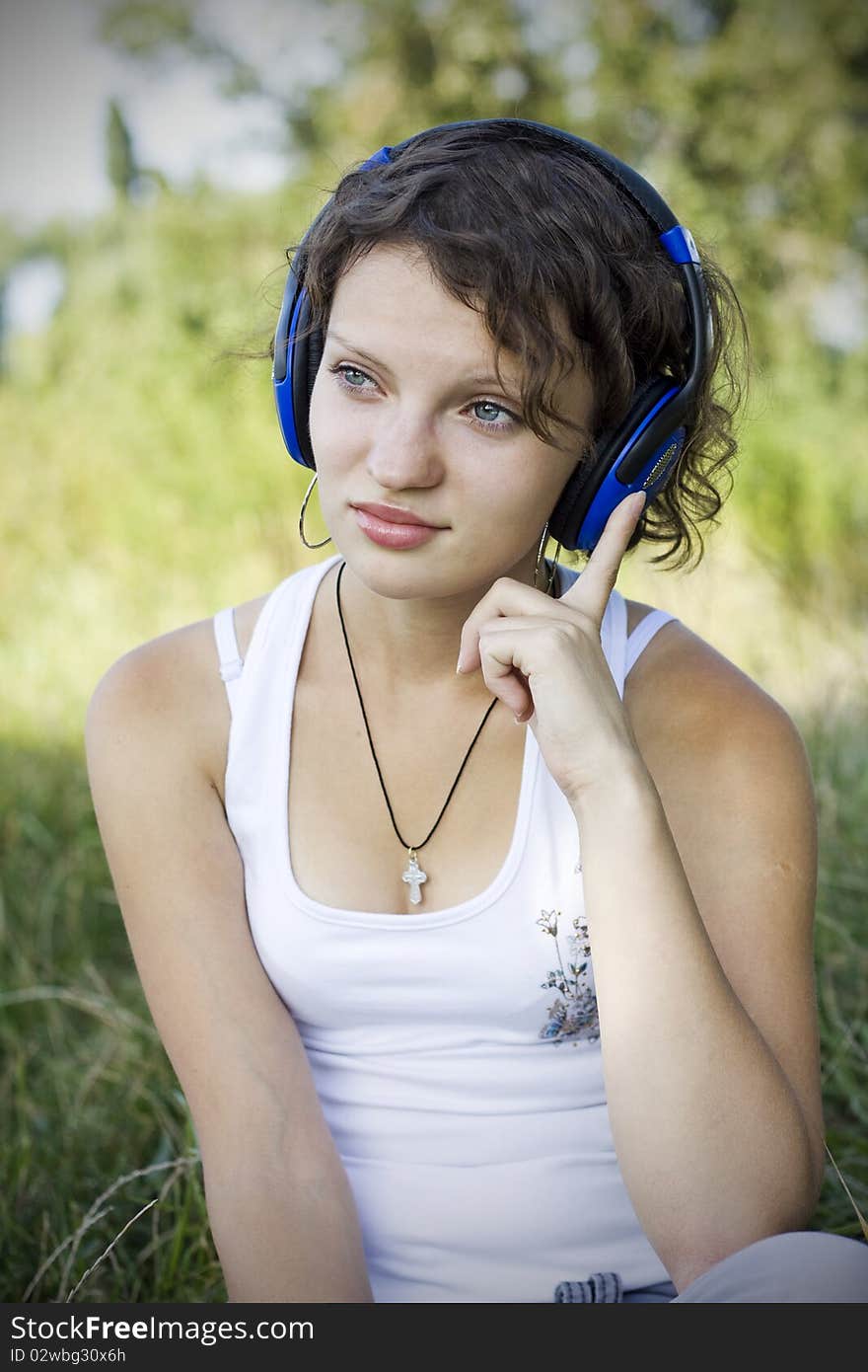 Young girl listens to music on the nature