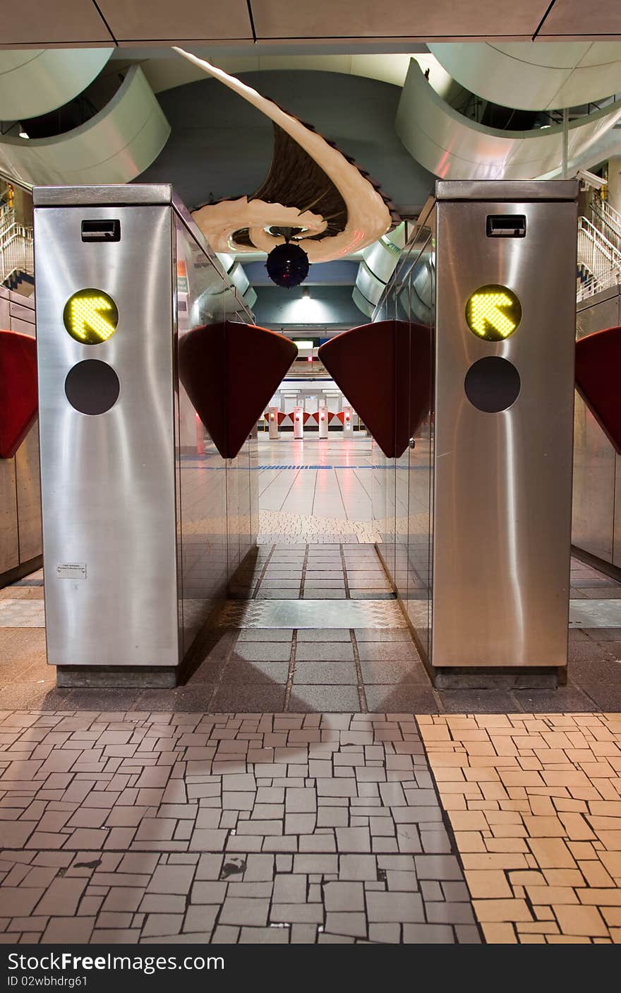 Turnstiles in underground railway station.  Green arrows pointing to the way forwards.  Red barriers preventing progress. Turnstiles in underground railway station.  Green arrows pointing to the way forwards.  Red barriers preventing progress.