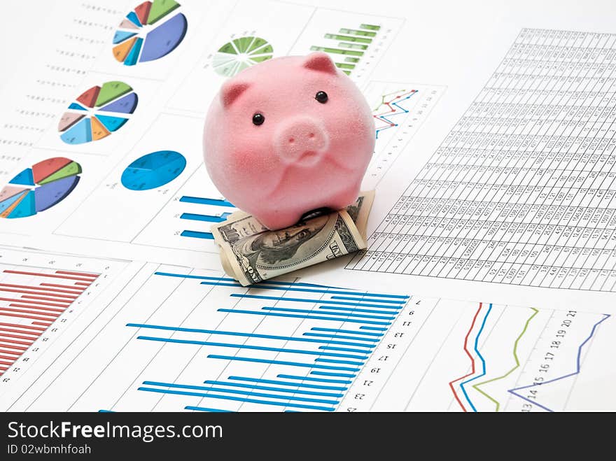 Piggy bank on money with business charts. Piggy bank on money with business charts